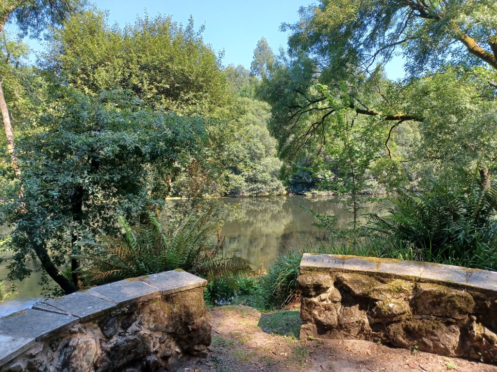 Clearing with a stone wall overlooking the river Ulla.